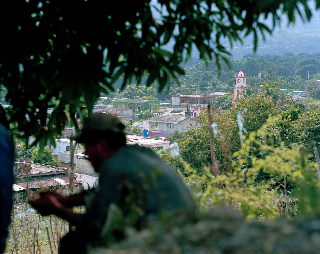 Ein Landarbeiter rastet, Dorf Actopan im Hintergrund, Provinz Veracruz, Mexico, Amerika