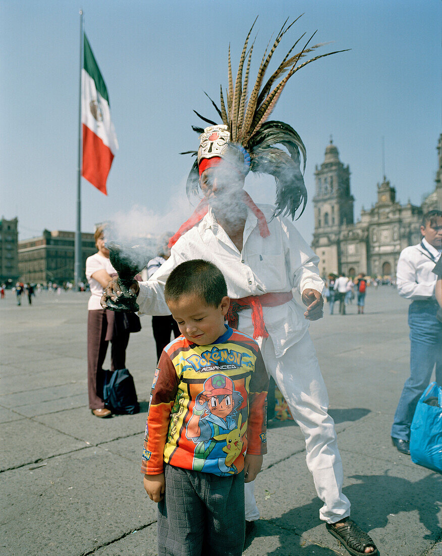 Ein Mann im Aztekenkostüm und Menschen auf dem Platz vor der Kathedrale, Zocalo, Mexico City, Mexico, Amerika