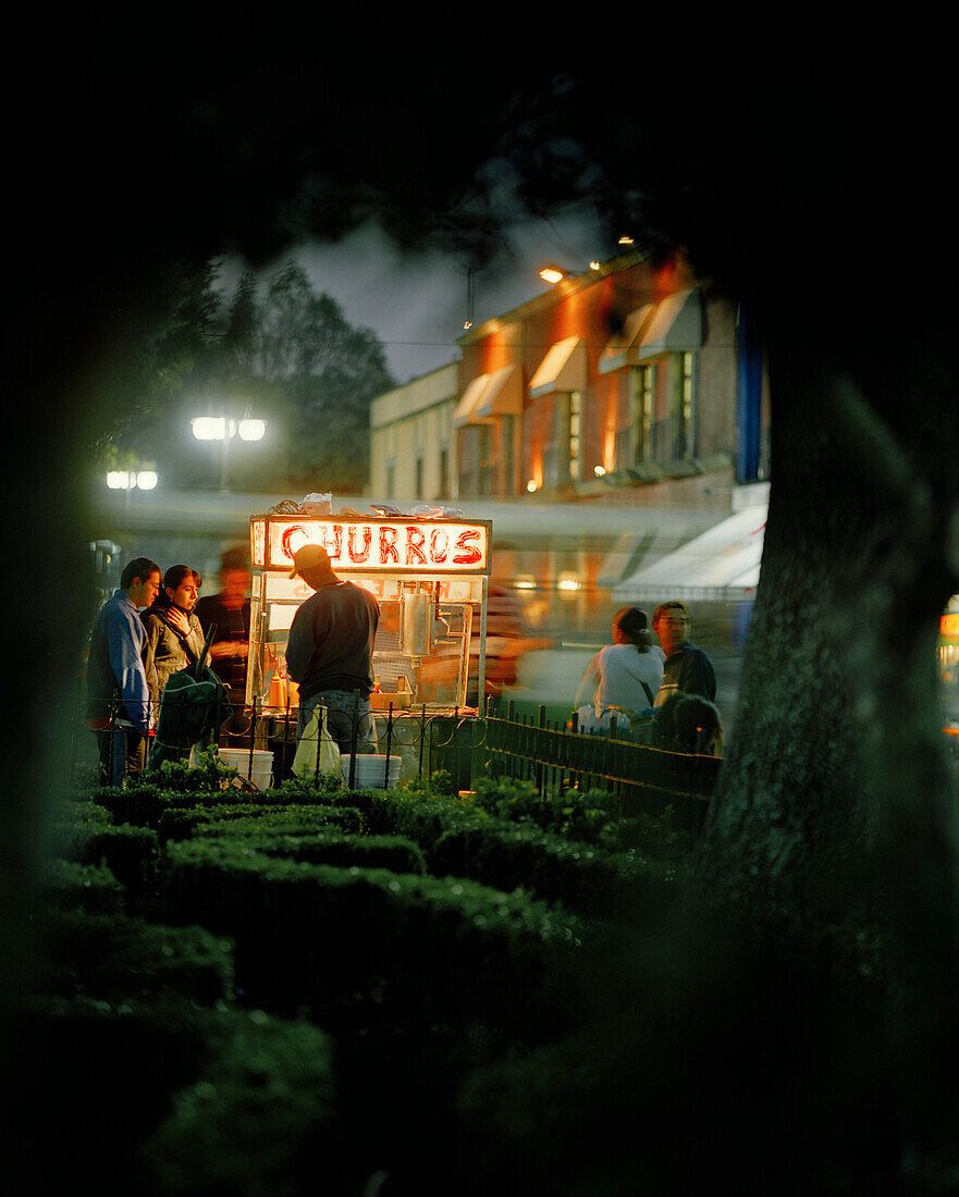 People at a sales stand for churros in the evening, Square Jardin Hidalgo, Centro Historico at Coyoacan, Mexico City, Mexico, America