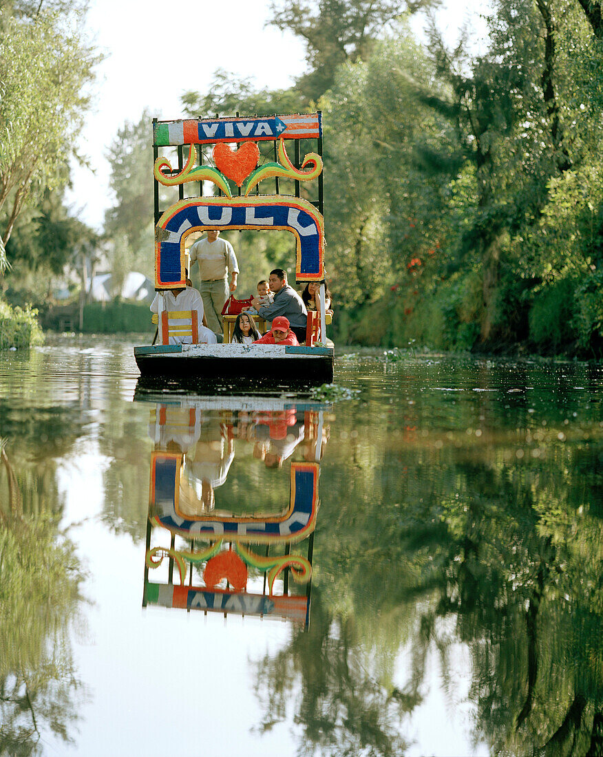 Menschen auf einem Ausflugsboot zwischen schwimmenden Inseln, Canales Embarcadero, Xochimilco, Mexico, Amerika