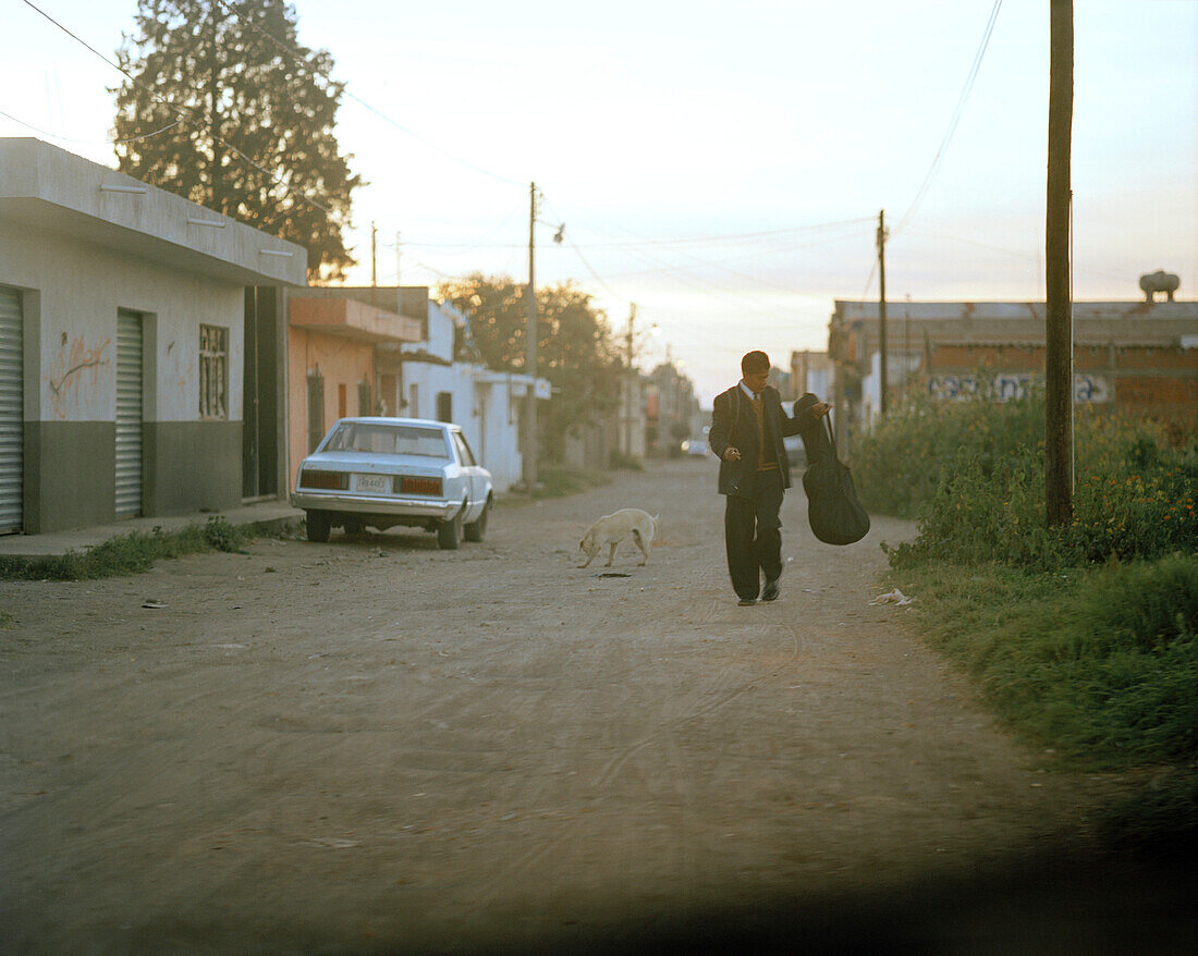 Ein Mann mit Gitarre in einer Strasse der Stadt Cholula am Abend, Provinz Puebla, Mexiko, Amerika