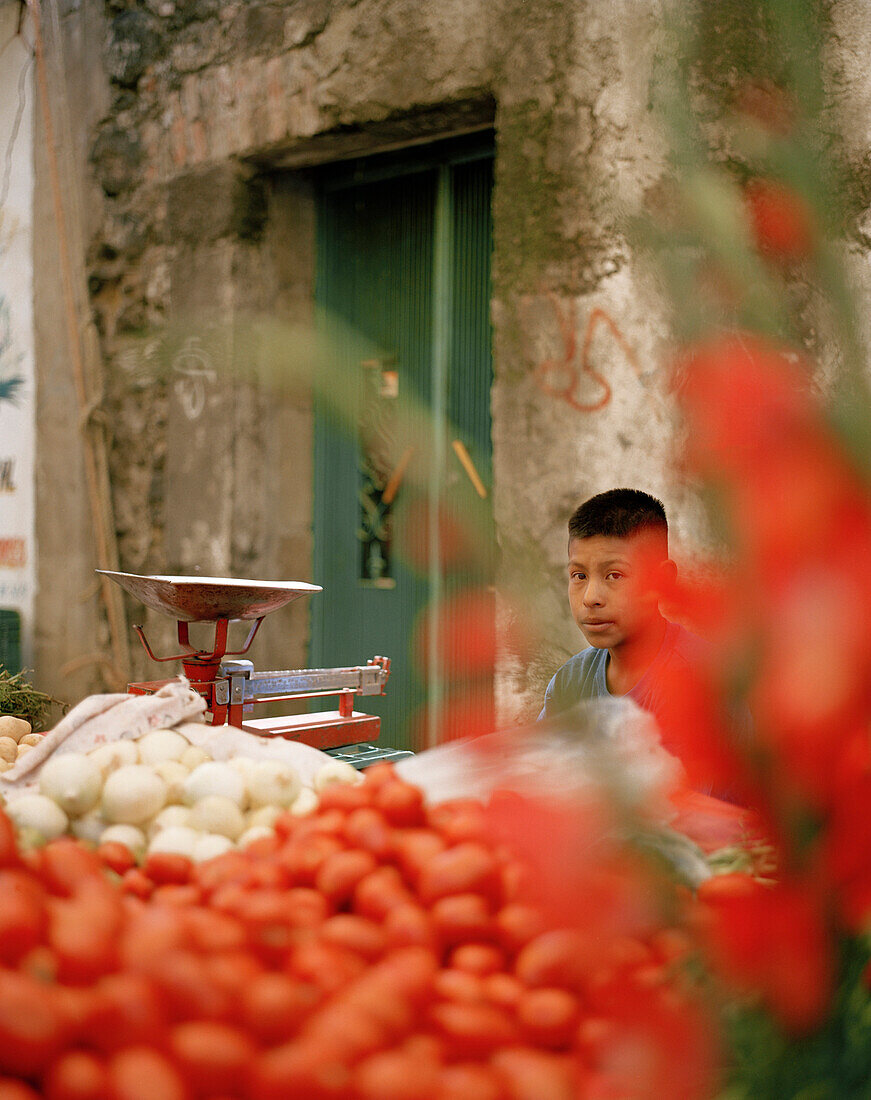 Boy at a market stand with vegetables and flowers at the village San Nicholas los Ranchos, Puebla province, Mexico, America