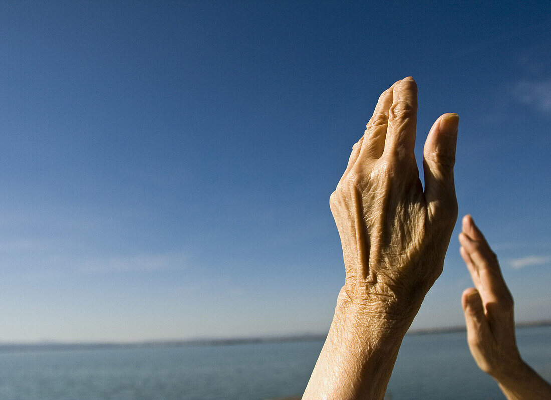 Adult, Adults, Aged, Arms raised, Blue, Blue sky, Color, Colour, Contemporary, Daytime, Detail, Details, Elder, Elderly, Exterior, Female, Free, Freedom, Gesture, Gestures, Gesturing, Hand, Hands, Horizon, Horizons, Human, Mature adult, Mature adults, Mat