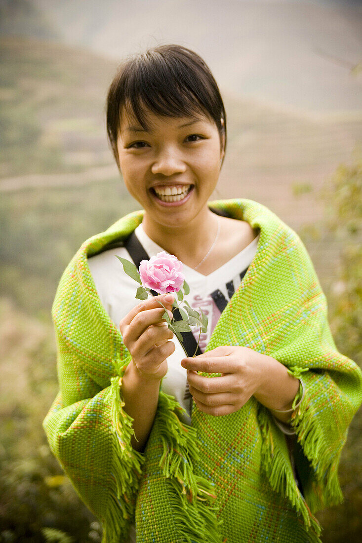 Asiate, Asiaten, Asien, Aussen, Blick Kamera, Blume, Blumen, China, Draussen, Eine Person, Eins, Erwachsene, Erwachsener, Ethnisch, Farbe, Frau, Frauen, Freude, Gesichtsausdruck, Gesichtsausdrücke, Glück, Glücklich, Guangxi, Halbfigur, Halten, Jugend, Jun