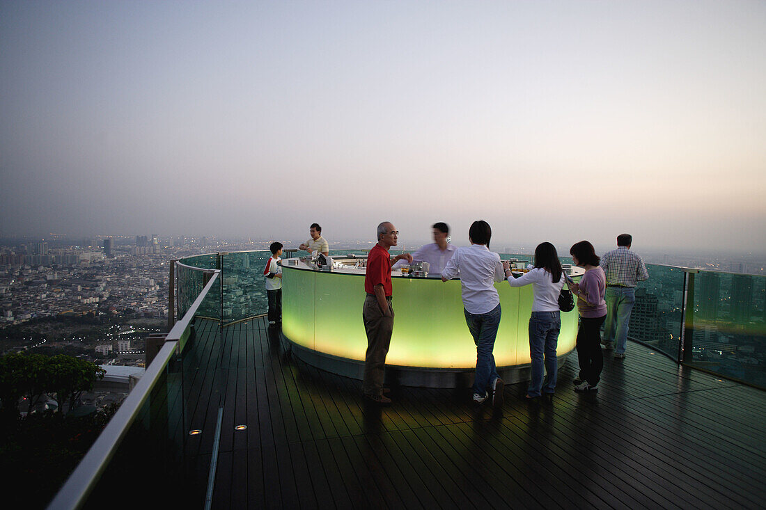 People staying at Sirocco Bar of The Dome which is loacted on the 62nd floor of the State Tower at Bangkok's Silom Road, having a cocktail while enjoying the magnificant view over the City of Angles, Thailand, Southeast Asia
