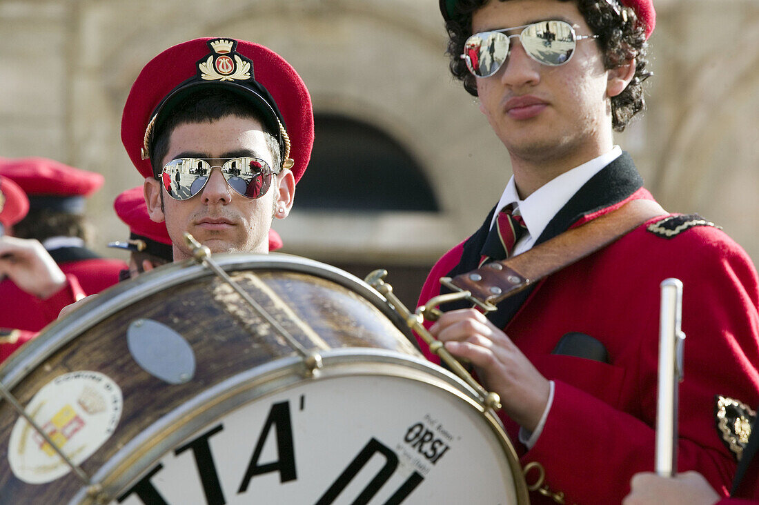 Musicians dressed in red costumes for the village Easter processions. Ispica. Sicily. Italy