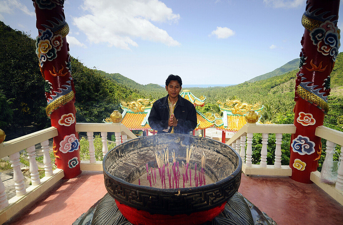 Man praying in Kuan Yin Temple, Ko Phangan, Ko Pha Ngan, Thailand