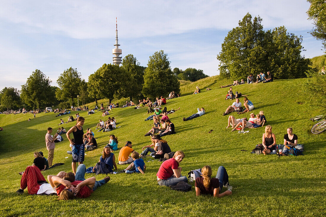 Junge Leute sitzen im Gras, Tollwood Festival, München, Deutschland