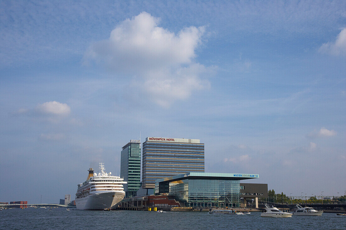 Cruise ship on the river Het Ij next to high rise buildings, Amsterdam, Netherlands, Europe