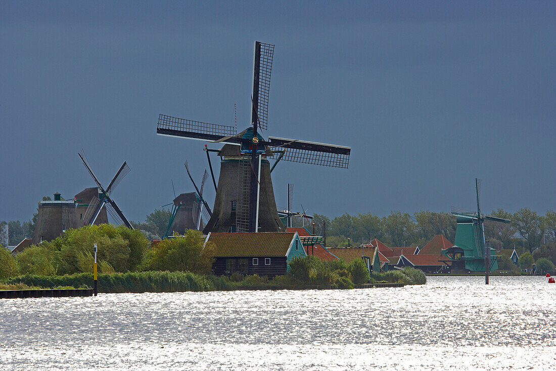 Windmills at open-air museum Zaanseschans at the river Zaan at a stormy atmosphere, Netherlands, Europe