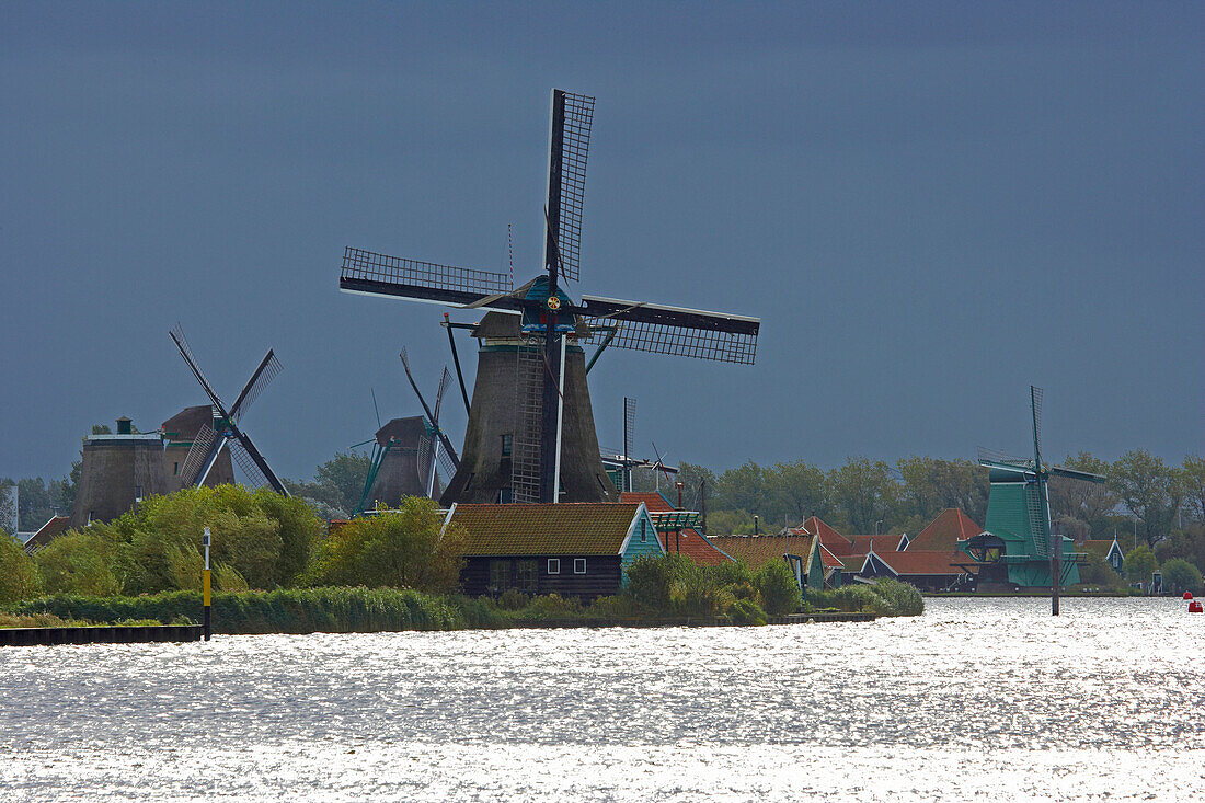 Windmühlen im Freilichtmuseum Zaanseschans am Fluss Zaan bei Gewitterstimmung, Holland, Europa