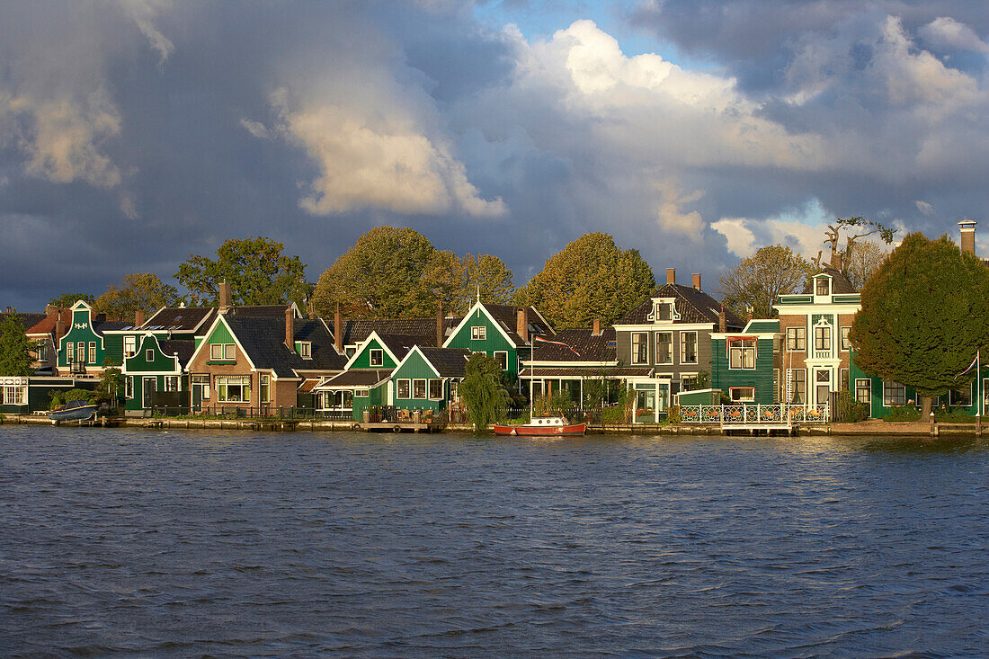 Historische Wohnhäuser am Fluss Zaan unter Wolkenhimmel am Morgen, Zaandijk, Holland, Europa