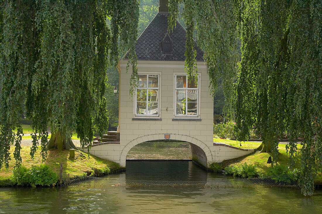 Hut on a bridge over Merwede canal under willows, Netherlands, Europe