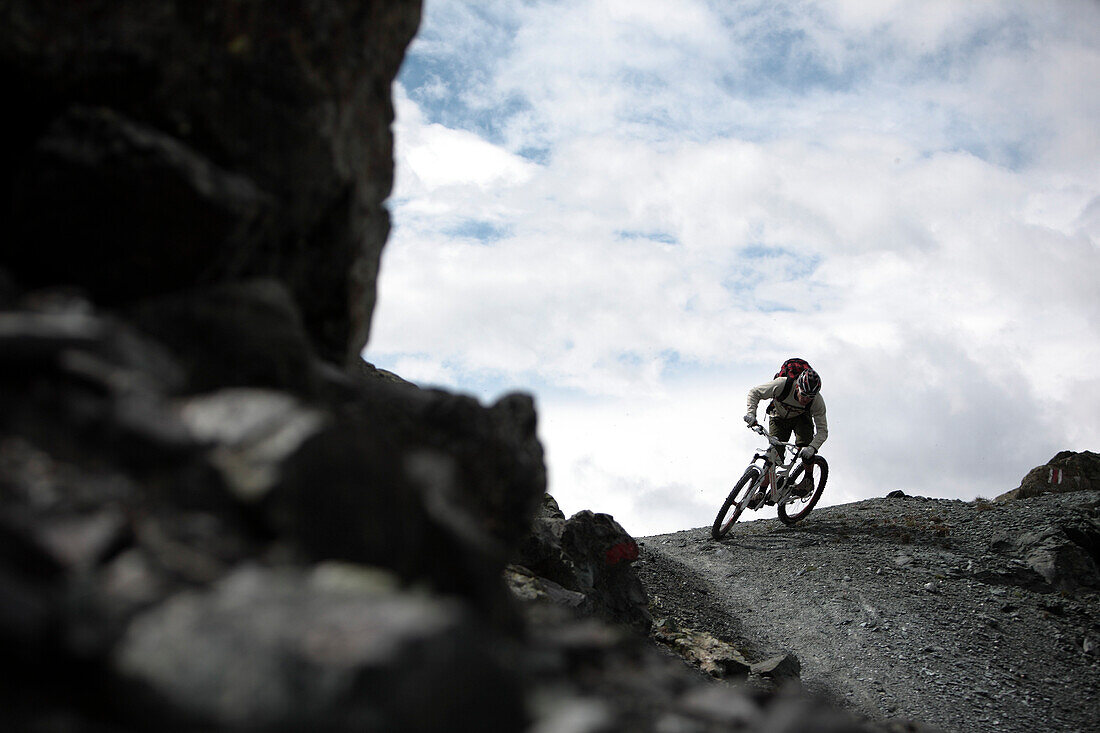 Mountainbiker fährt auf einem Pfad in den Bergen, Ischgl, Tirol, Österreich