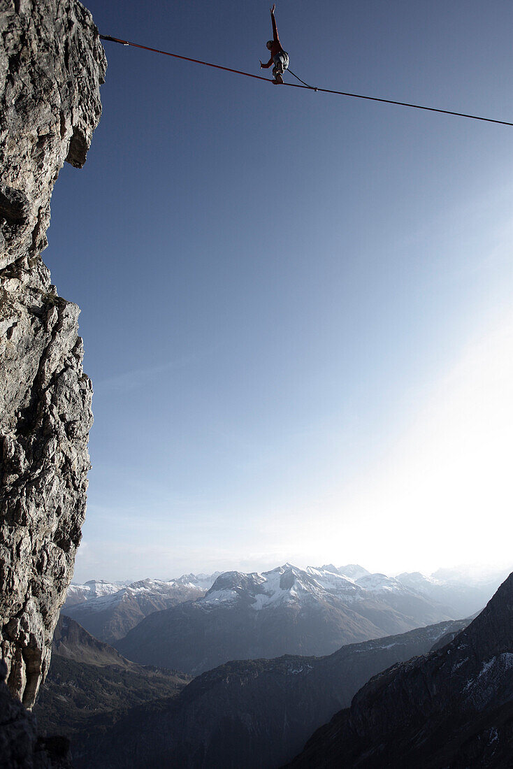 Man balancing on a rope over an abyss, slackline in the mountains, Oberstdorf, Bavaria, Germany