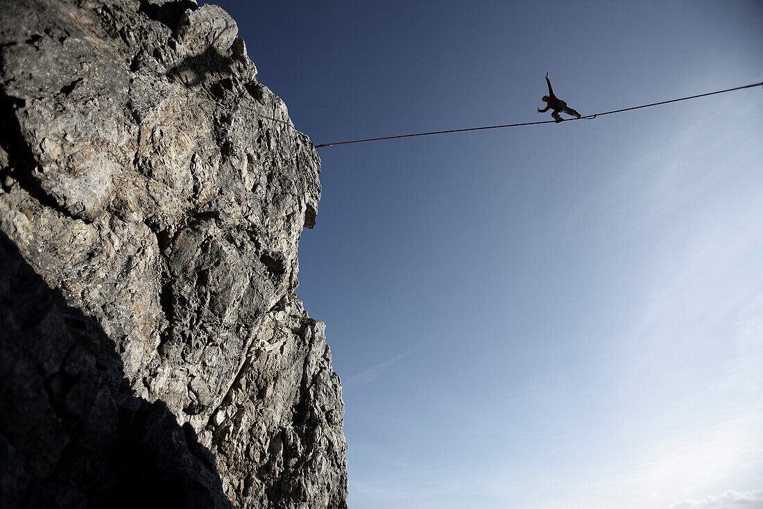 Mann balanciert auf einem Seil über einem Abgrund, Slackline in den Bergen, Oberstdorf, Bayern, Deutschland
