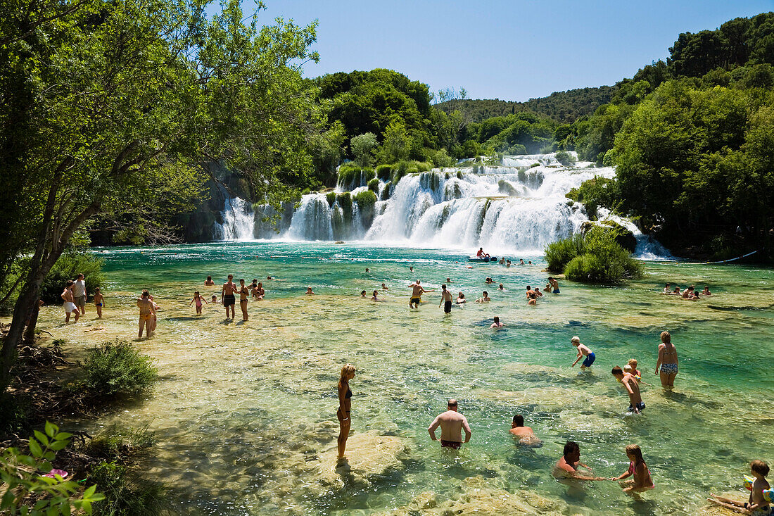 Menschen baden im Fluss vor den Krka Wasserfällen, Krka Nationalpark, Dalmatien, Kroatien, Europa