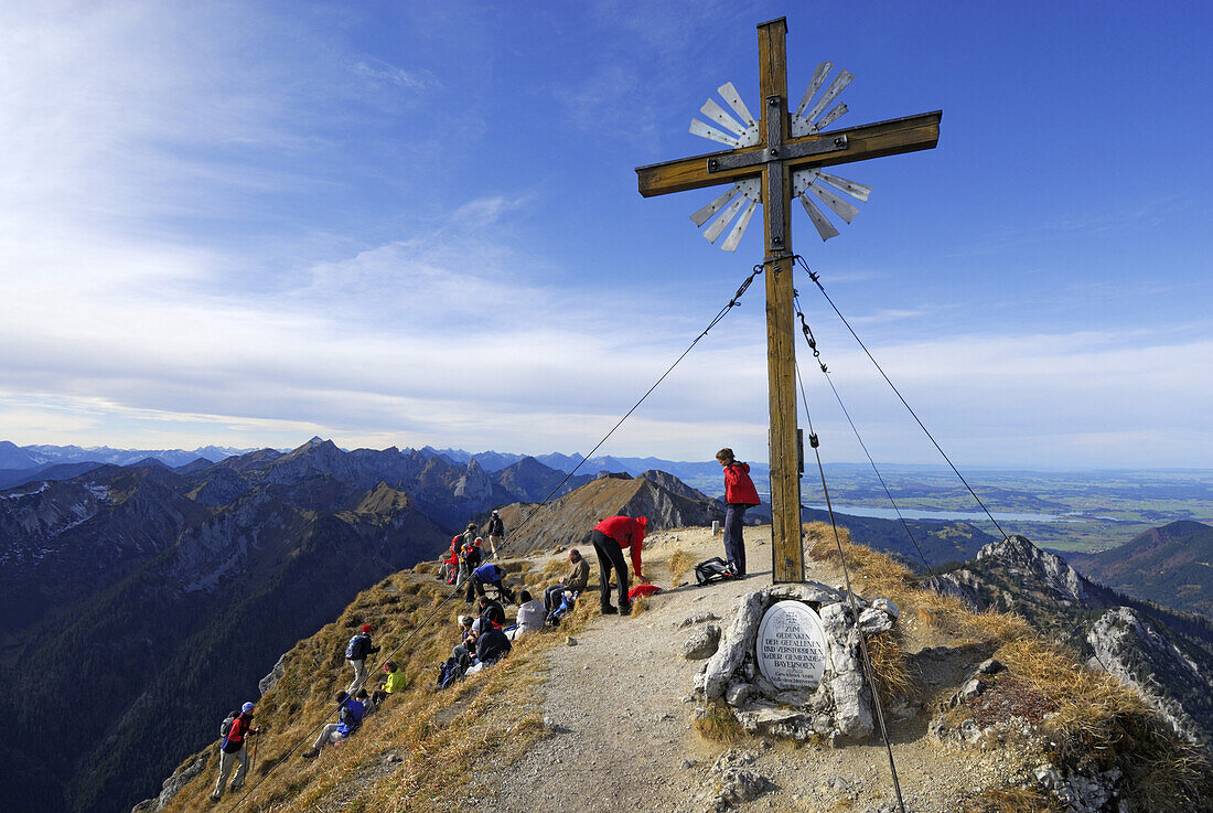 Hikers near summit cross of Klammspitze, Ammergau Alps, Pfaffenwinkel, Bavaria, Germany