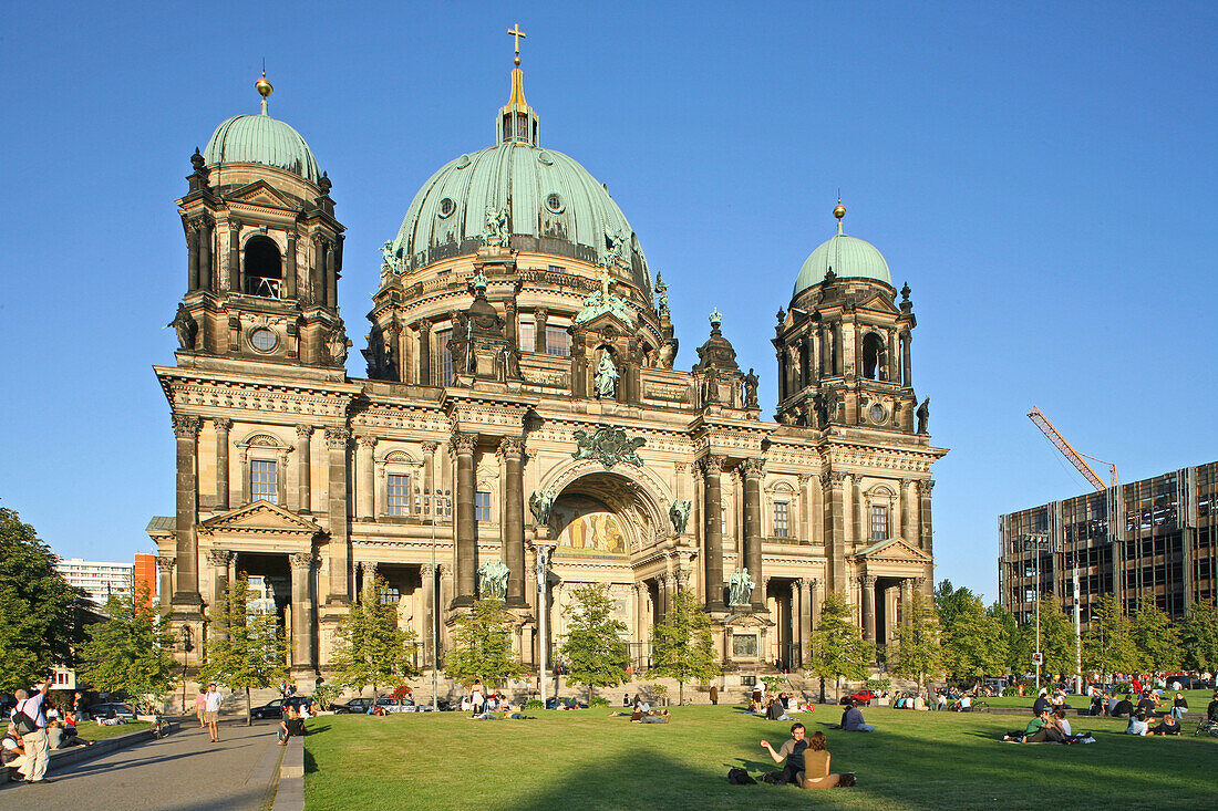 Touristen auf dem Rasen des Lustgartens vor Berliner Dom