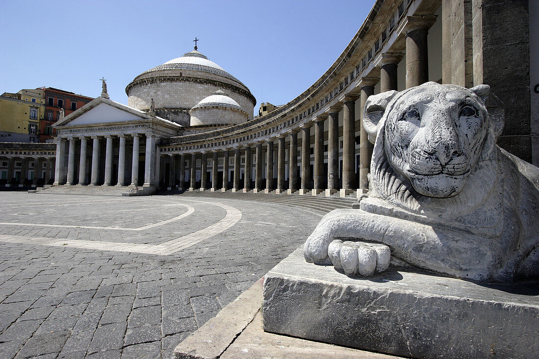 A stone carved lion on the Piazza del Plebiscito with Church of San Francesco di Paola in the background. Naples. Campania. Italy