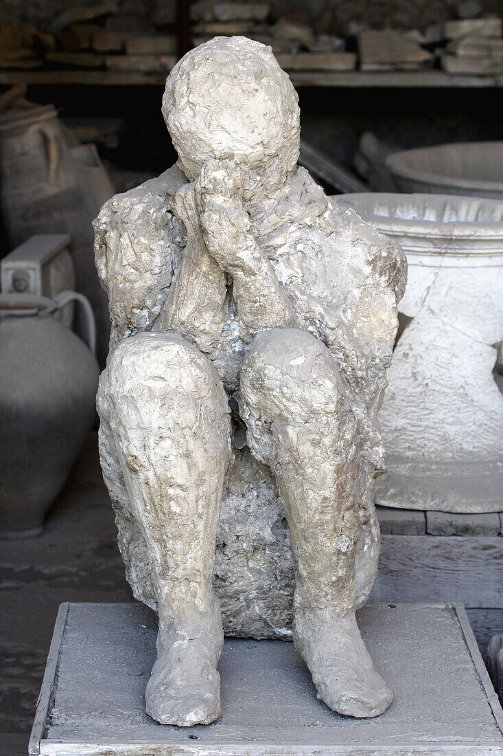 Plaster cast of a human boy in ancient ruins city of Pompei. Campania. Italy