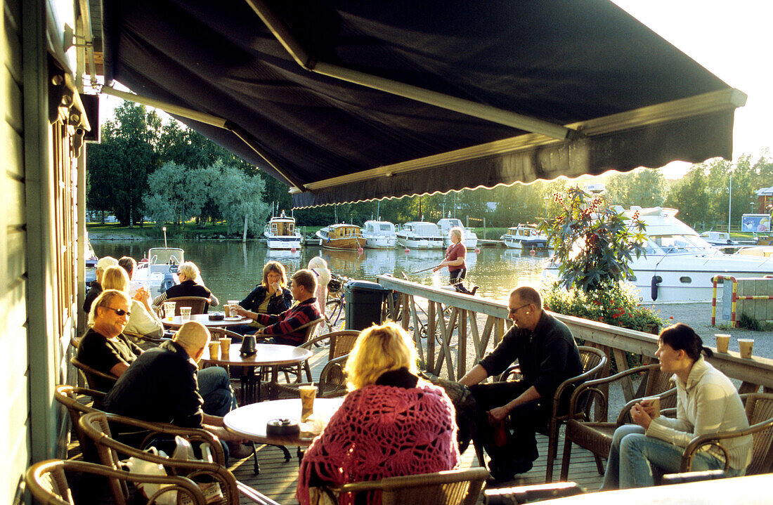 Menschen sitzen in einem Café am Wasser, Porvoo, Finnland, Europa