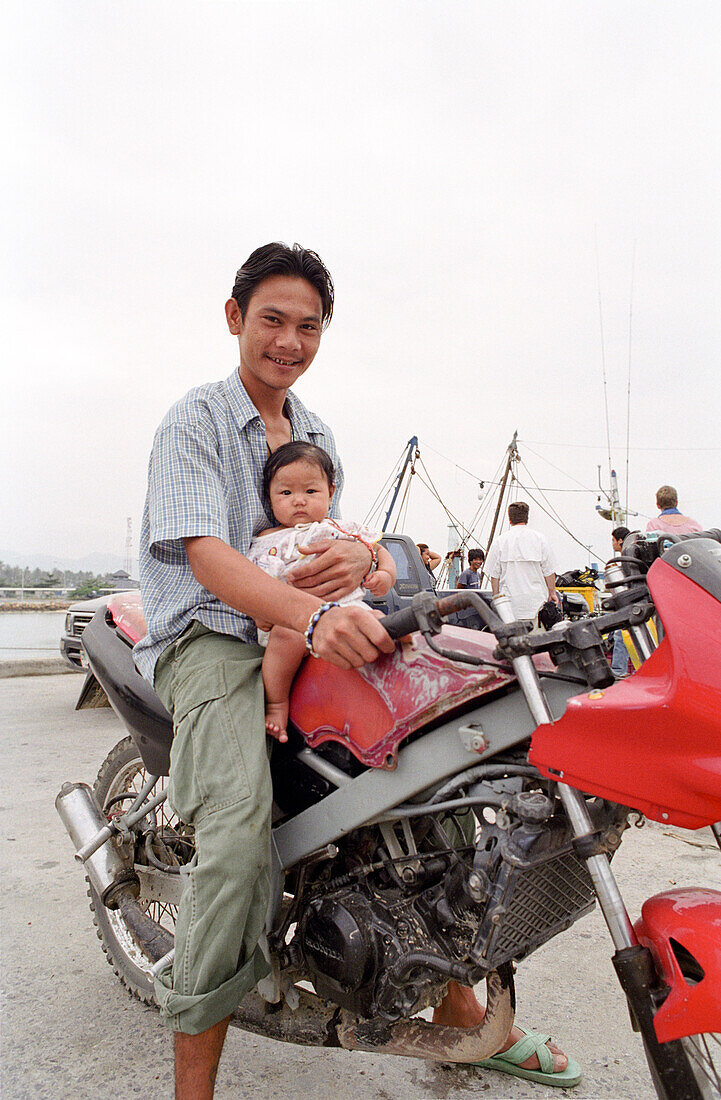 Vater mit Kind auf einem Motorrad, Thong Sala, Ko Pha Ngan, Thailand