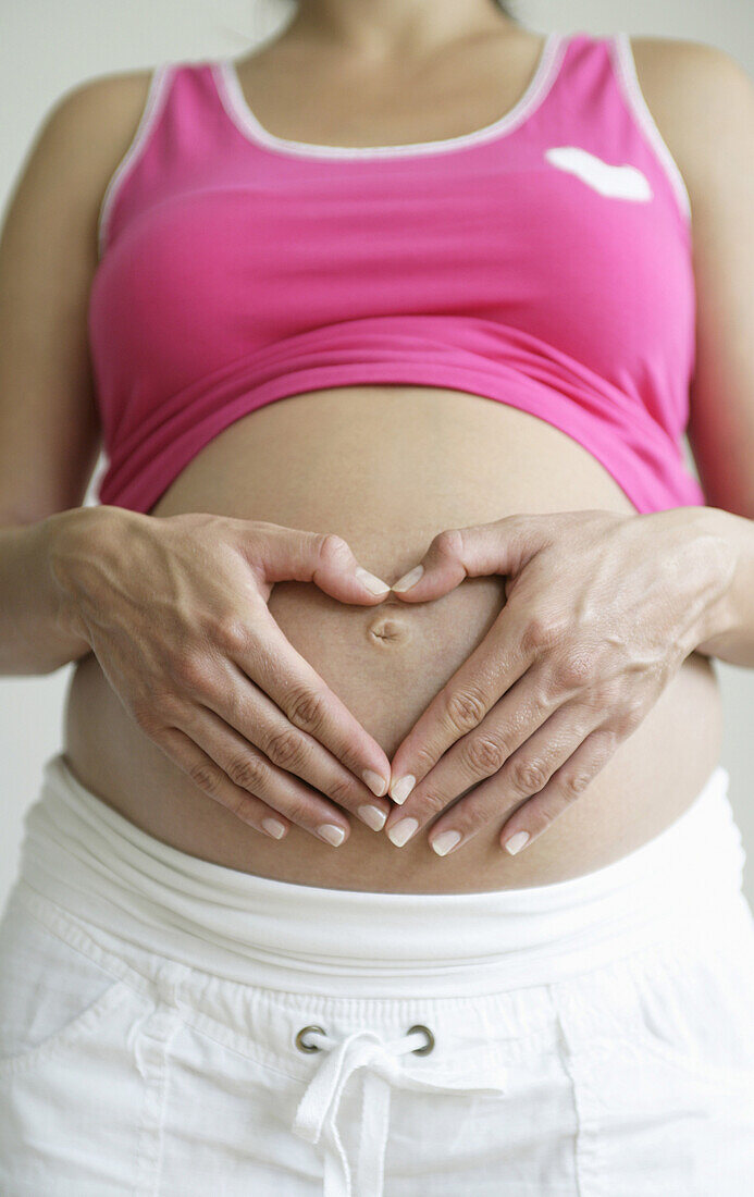 Schwangere Frau berührt ihren Bauch