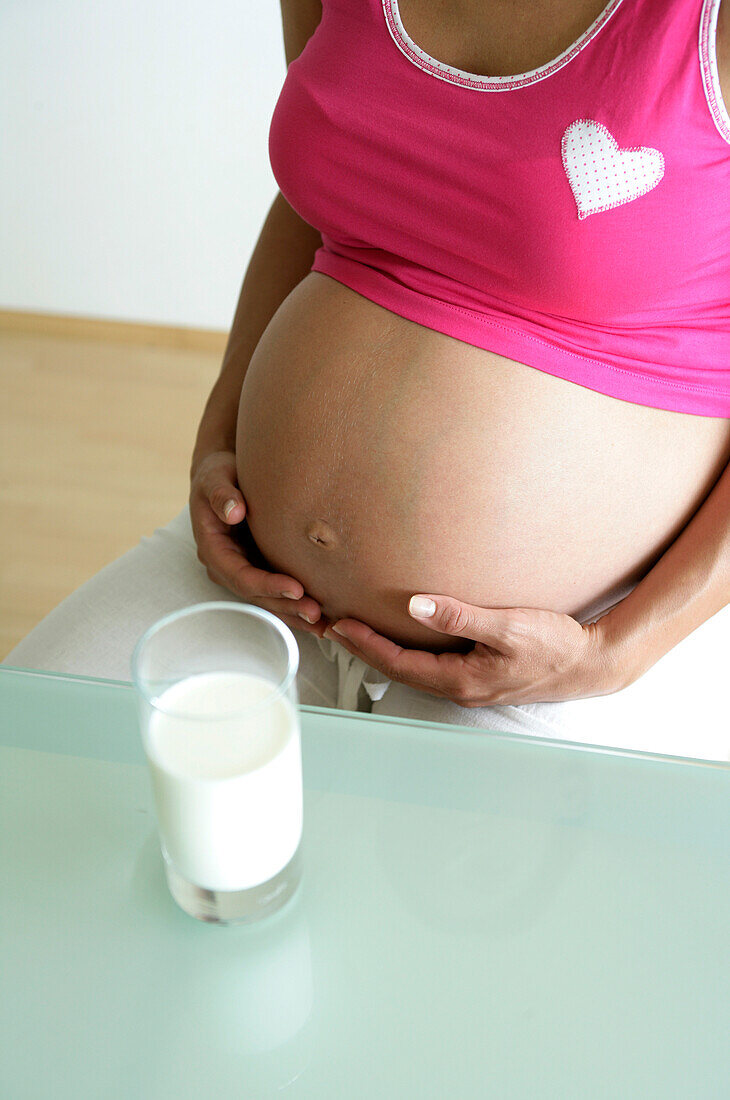 Schwangere Frau mit einem Glas Milch