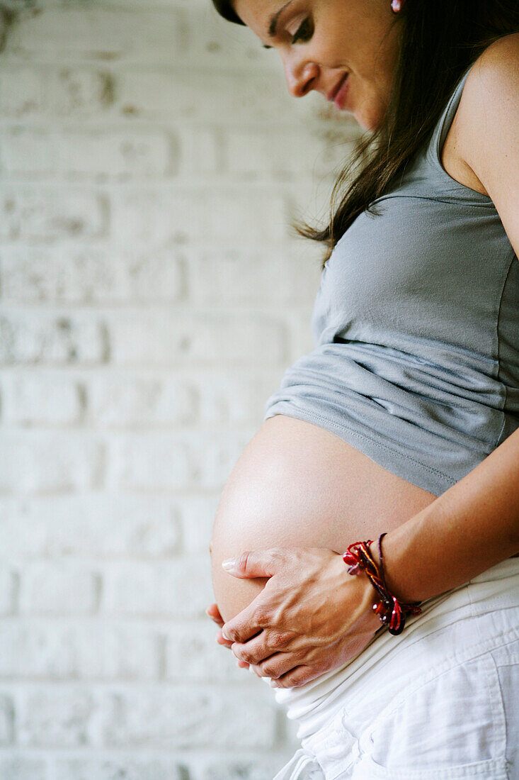 Schwangerer Frau berührt ihren Bauch