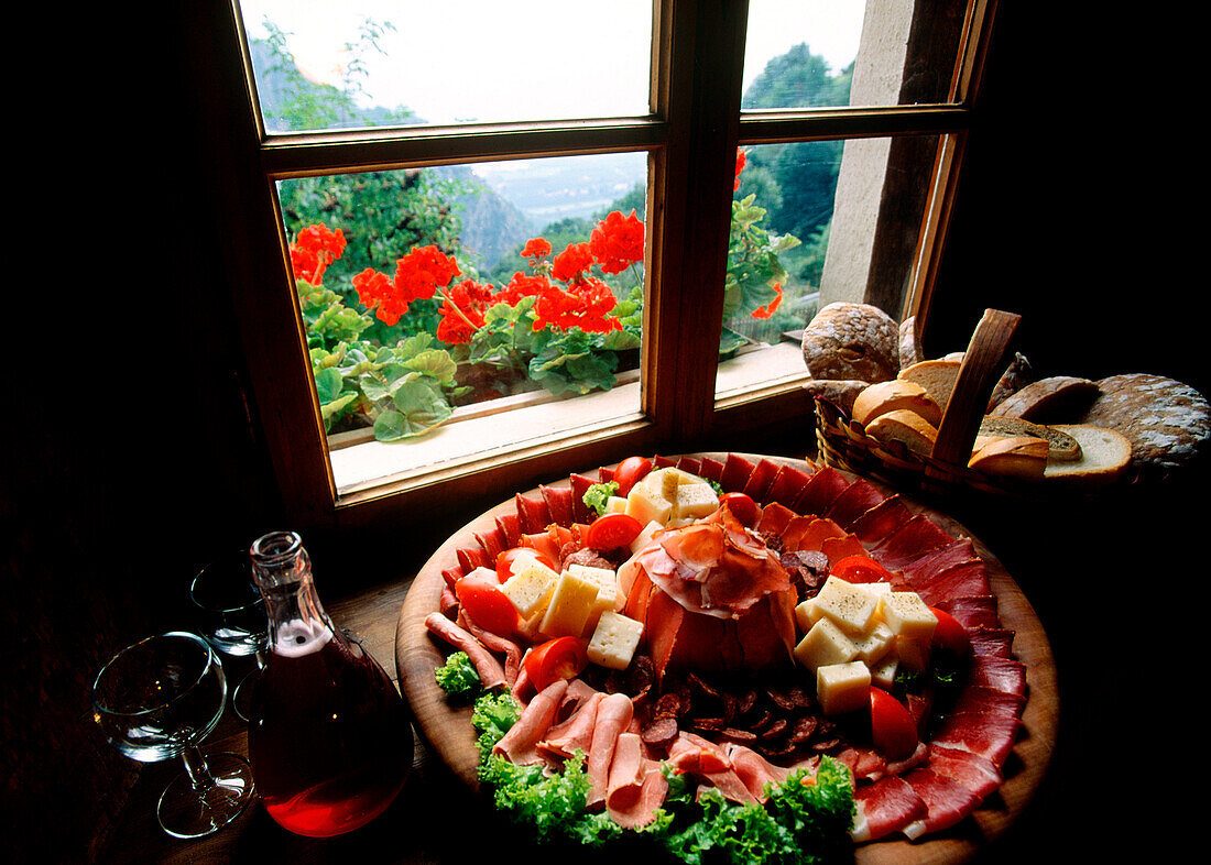 Ein Brett mit Aufschnitt vor dem Fenster eines Gasthofs, Südtirol, Italien, Europa