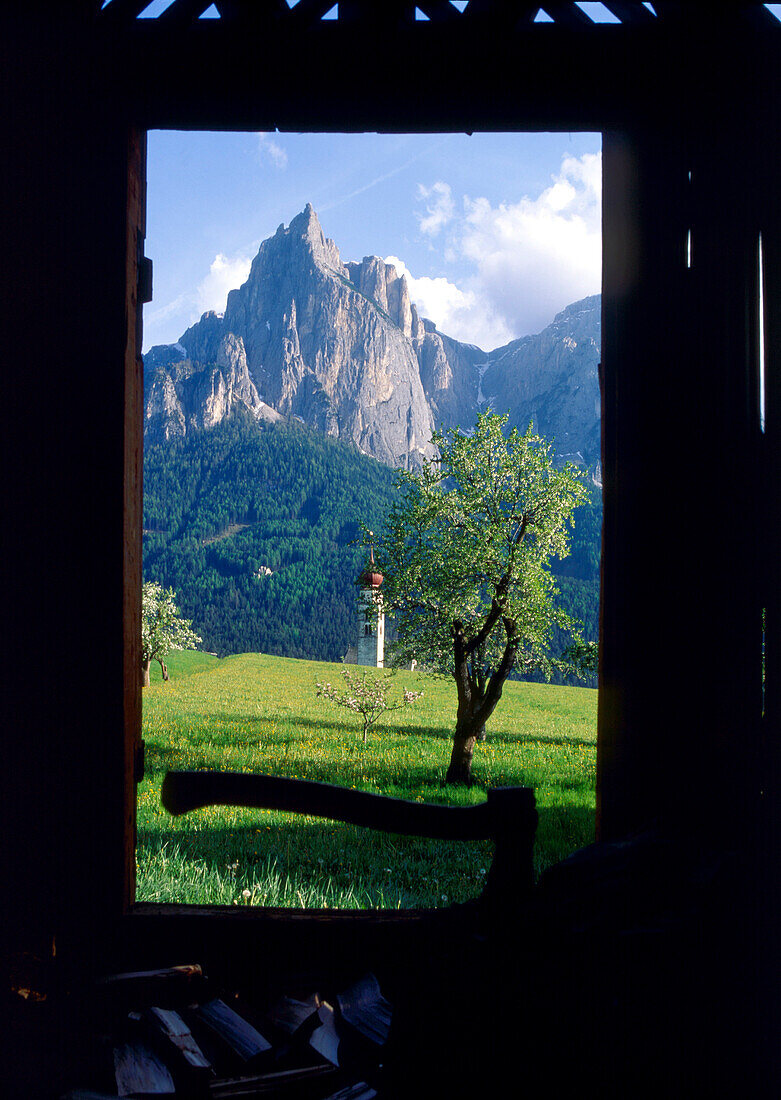 View out of the door of a shed at mountain scenery and a steeple, Sciliar, Dolomites, South Tyrol, Italy, Europe