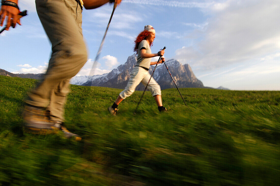 Eine Frau und ein Mann beim Nordic Walking in einer Berglandschaft, Schlern, Südtirol, Italien, Europa