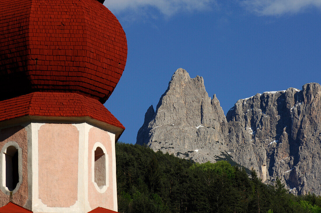 The steeple of Saint Oswald church in front of mountains, Kastelruth, South Tyrol, Italy, Europe