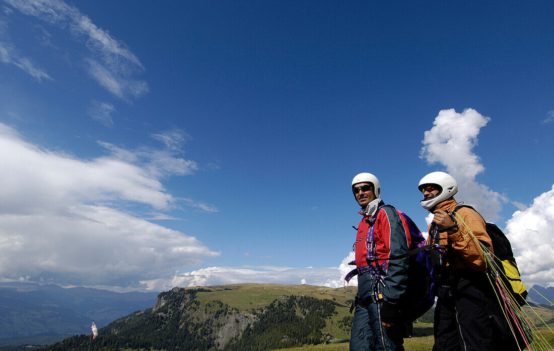 Zwei Männer mit Helm vor Bergen und blauem Himmel, Seiser Alm, Eisacktal, Südtirol, Italien, Europa