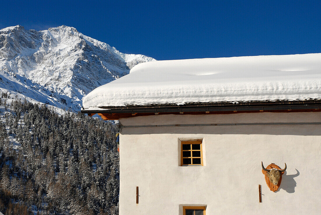 Das Gasthaus Yak & Yeti vor schneebedeckten Bergen im Sonnenlicht, Sulden, Vinschgau, Südtirol, Italien, Europa