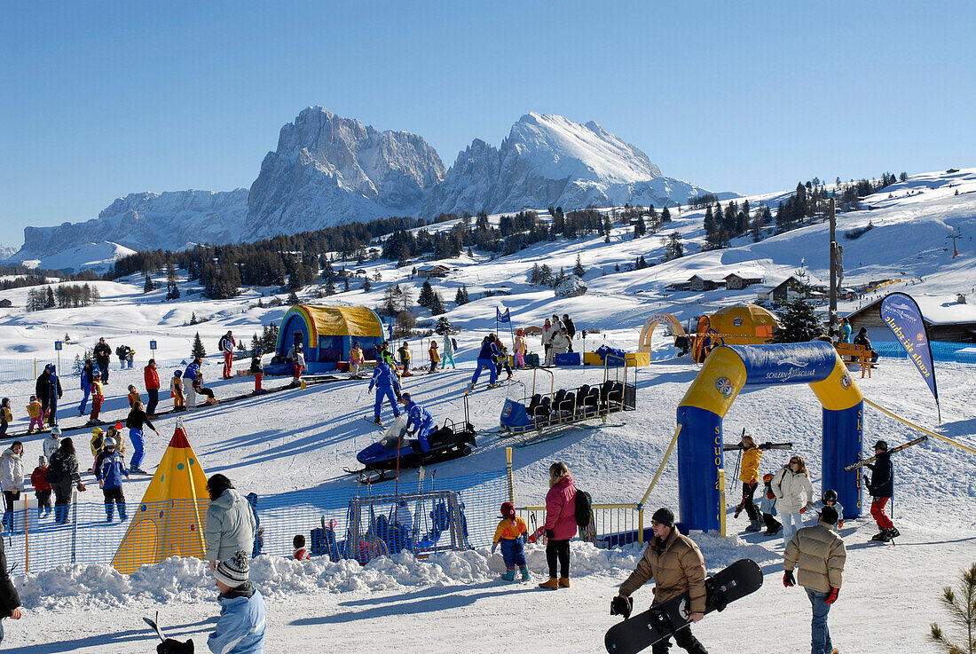 Touristen in einem verschneiten Skigebiet im Sonnenlicht, Seiser Alm, Eisacktal, Südtirol, Italien, Europa