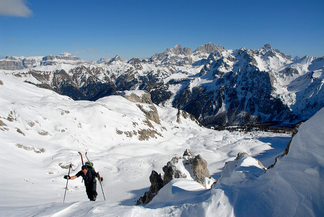 Ein Mann beim Aufstieg in verschneiter Berglandschaft, Dolomiten, Südtirol, Italien, Europa
