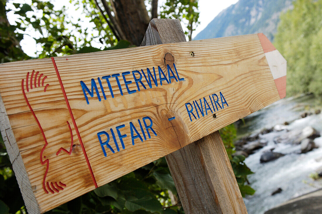 Wooden signpost in front of landscape with feeder, Glurns, Val Venosta, South Tyrol, Italy, Europe