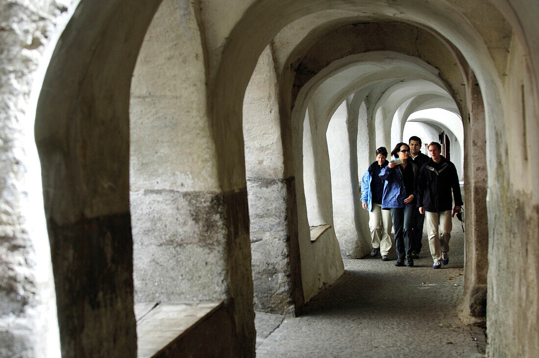 Menschen gehen durch einen Laubengang in der Altstadt, Glurns, Vinschgau, Südtirol, Italien, Europa