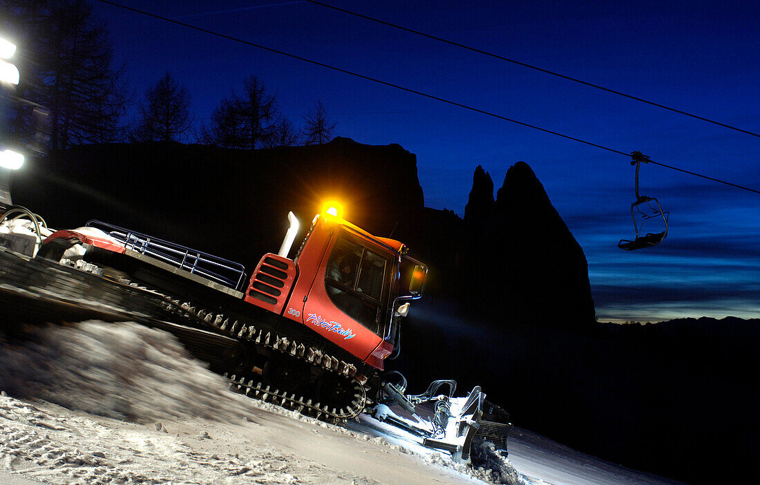 Caterpillars treating the ski slope at night, South Tyrol, Italy, Europe