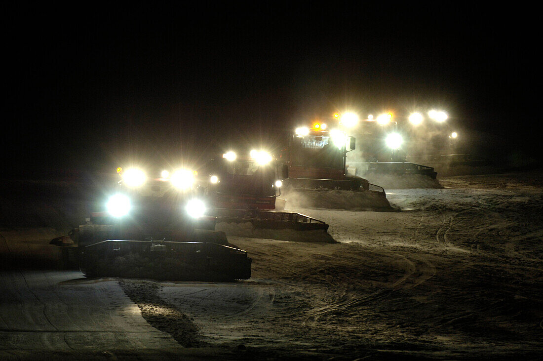 Raupenfahrzeuge bearbeiten bei Nacht die Skipiste, Südtirol, Italien, Europa