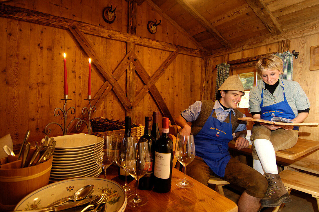 A man and a woman sitting at the restaurant of an alpine hut, Gostner Schwaige, Alpe di Siusi, South Tyrol, Italy, Europe