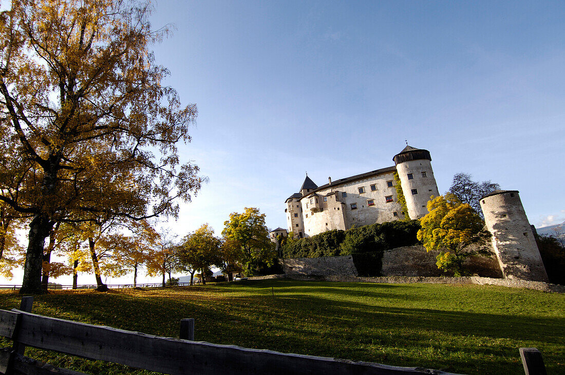 Schloss Prösels mit herbstlichen Bäumen im Sonnenlicht, Völs am Schlern, Südtirol, Italien, Europa