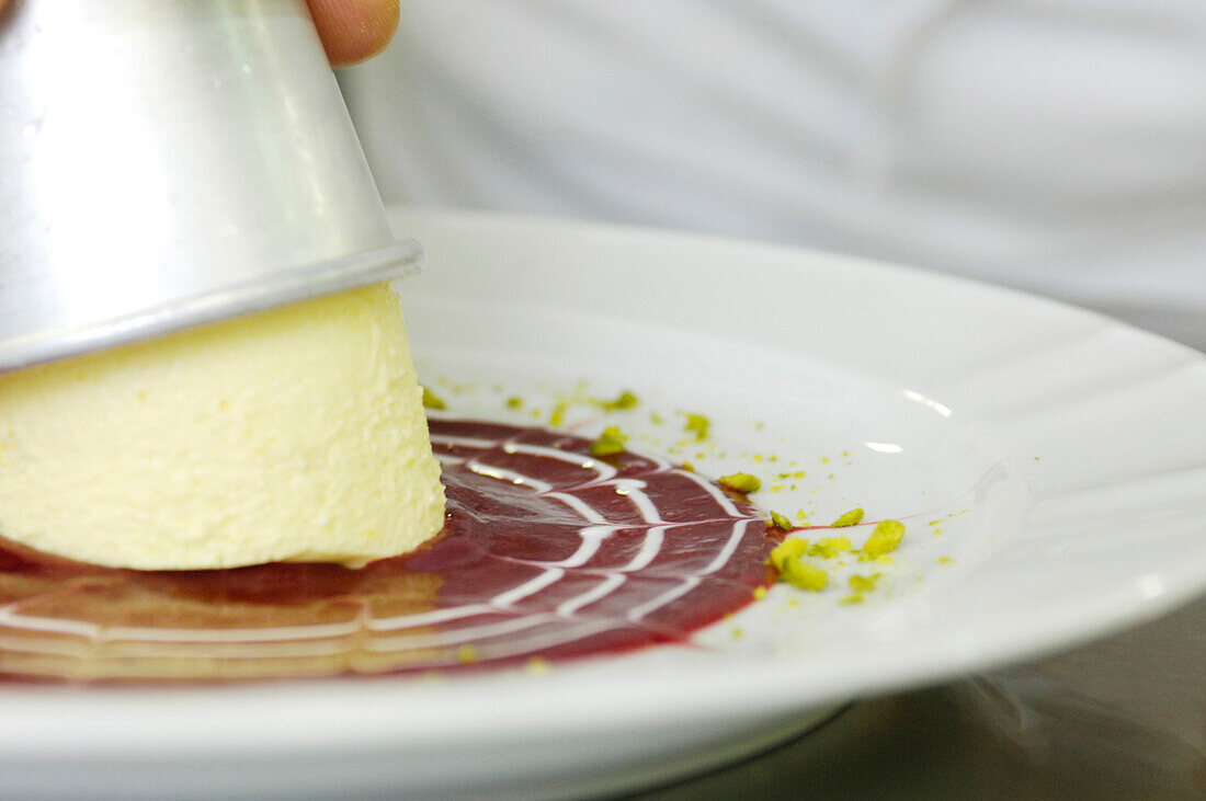 Cook preparing the dessert, Panna cotta with raspberry sauce, Gastronomy, South Tyrol, Italy