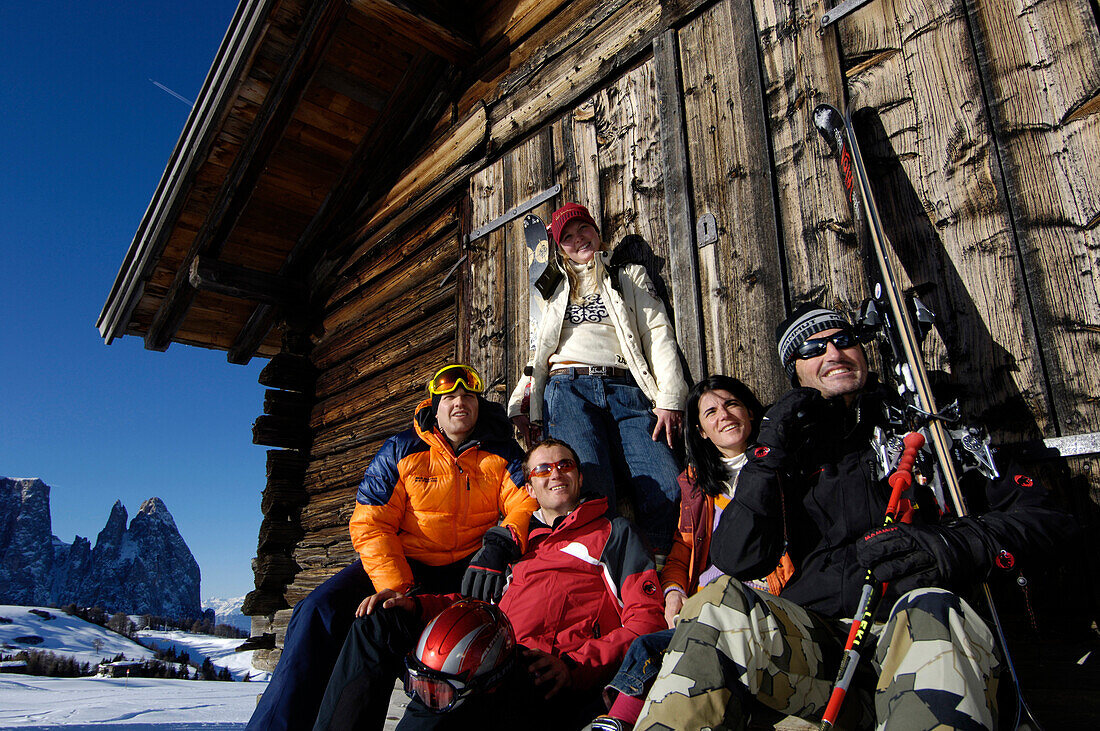 Eine Gruppe Skifahrer rasten vor einer Hütte, Seiser Alm, Schlerngebiet, Südtirol, Italien