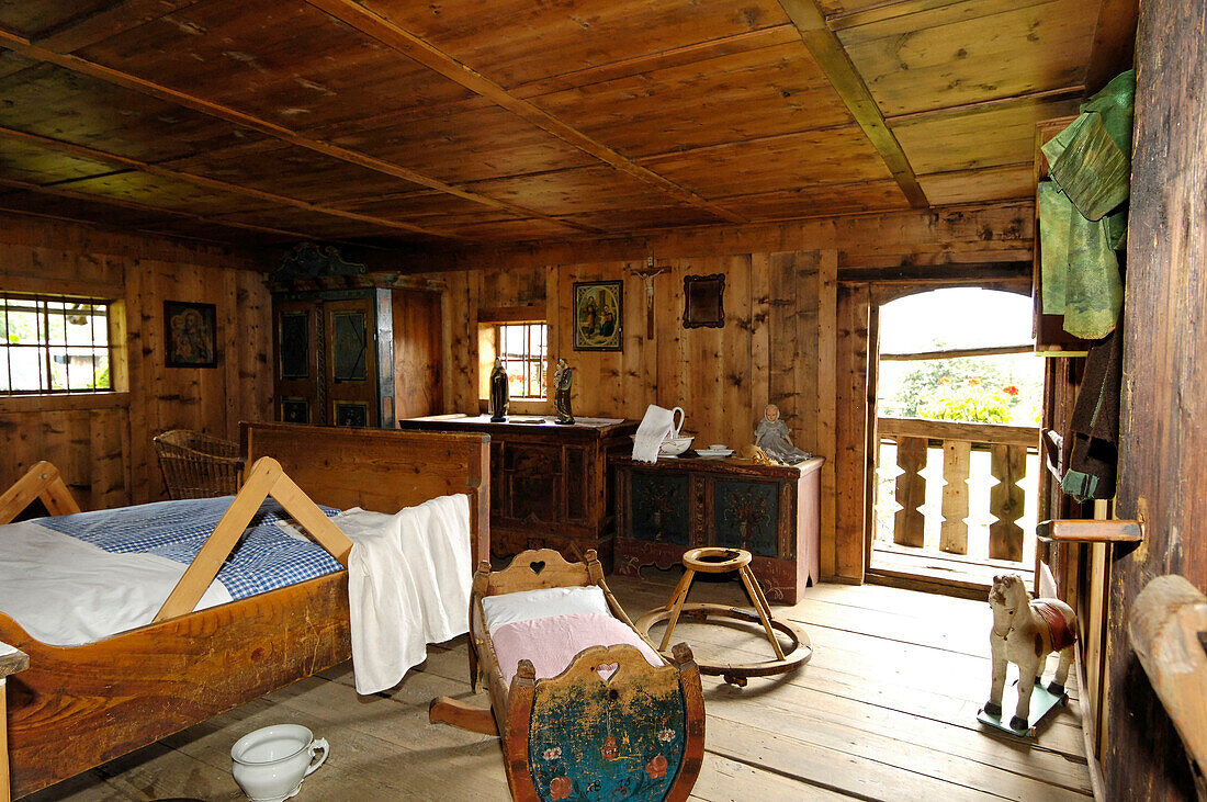 The farmhouse bedroom with bed, cradle and rocking horse, South Tyrolean local history museum at Dietenheim, Puster Valley, South Tyrol, Italy