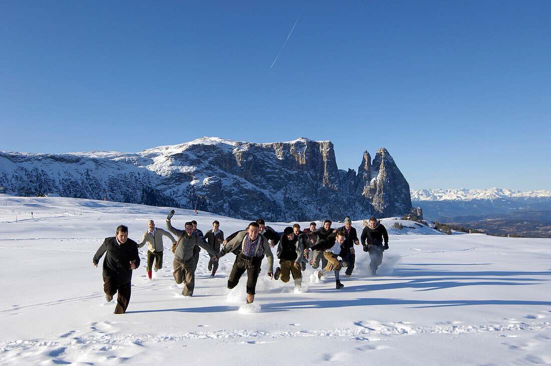 A group of men running through the snow, Seiser Alm, South Tyrol, Italy