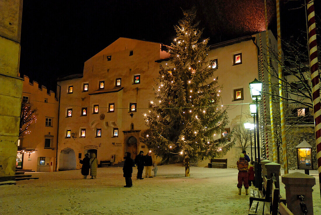 Kastelruth in Winter, village square piazza Kraus, Krausplatz with Christmas tree at night, Kastelruth, Castelrotto, South Tyrol, Italy