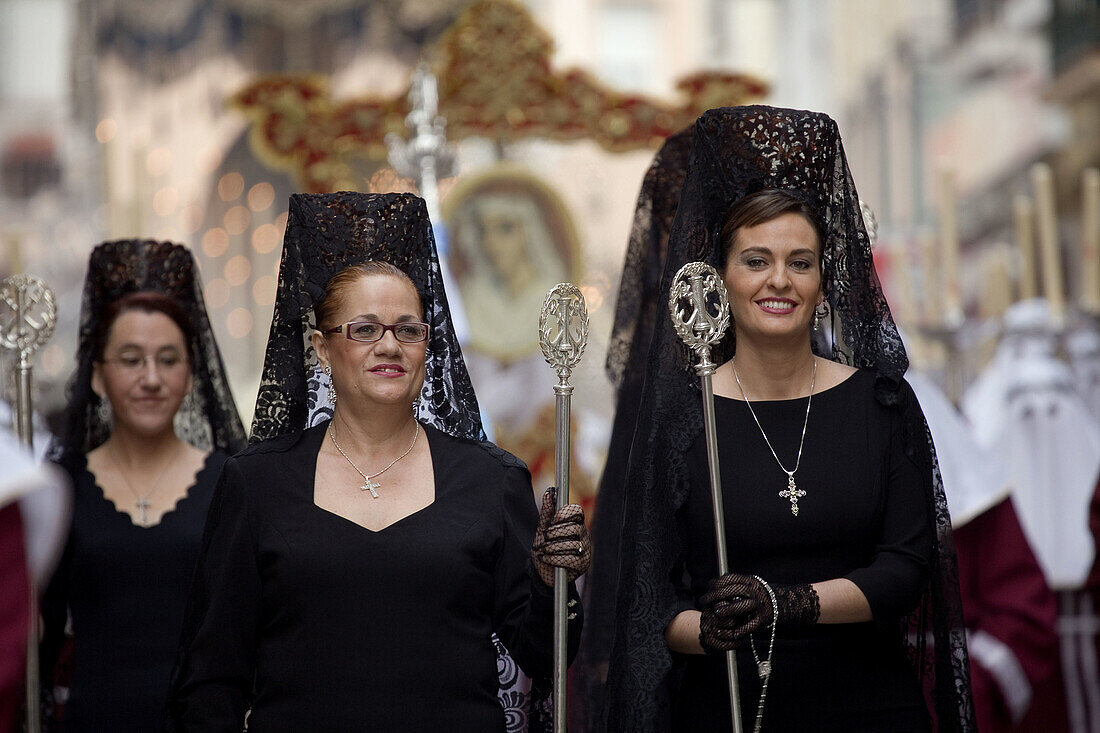 Women in traditional 'mantilla' during Holy Week procession, Malaga. Andalucia, Spain
